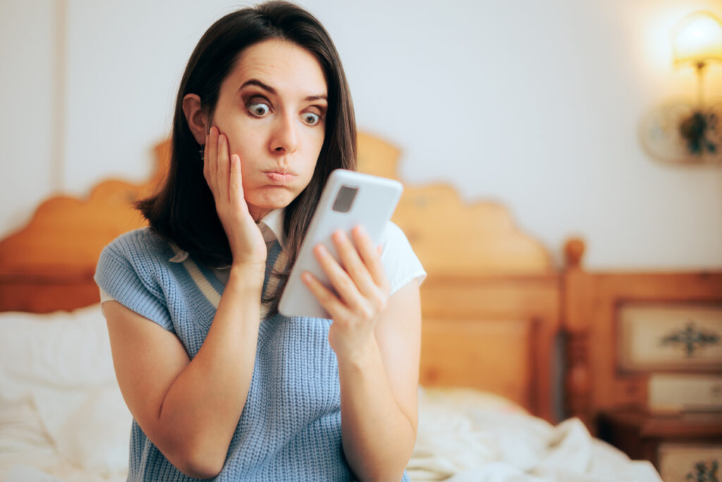 Funny woman in shock reading text message on her phone